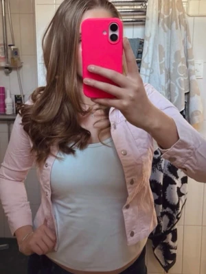 Ljusrosa jeansjacka  - Säljer en ljusrosa jeansjacka med klassisk krage, silverfärgade knappar och två bröstfickor. Jackan har en figurnära passform och långa ärmar. Perfekt för dig som vill addera lite färg till din outfit!💗💗💗💗💗