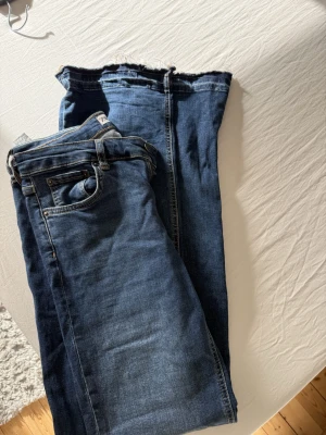Blå jeans från Zara - Säljer ett par jeans från Zara, det är utsvängda ner till, byxorna är lågmidjade och är tillverkade i ett slitstarkt denimtyg. Perfekta till en avslappnad vardagsstil.