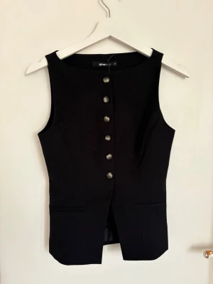 Topp - Svart topp i kostym material från Gina tricot i storlek xs aldrig använd, lappen är kvar