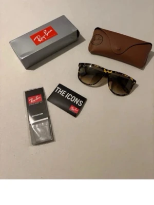 Ray-Ban leopardmönstrade solglasögon - Säljer ett par Ray-Ban solglasögon med leopardmönstrad båge och bruna tonade glas. Klassisk modell med cool retrostil. Kommer med originalfodral, putsduk och box. Perfekta för dig som vill sticka ut i solen!