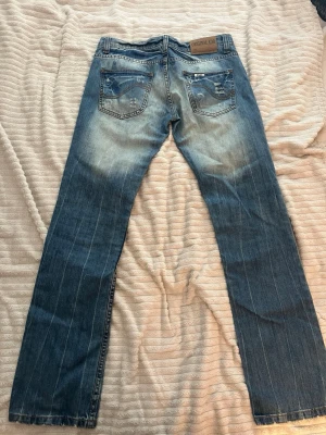 Blå slitna jeans från Original 20 - Står strl 30, men den e verkligen små i storlek passar snare strl xs-s skriv om du vill ha mått! 🥰Säljer ett par blå jeans från Original 20 med slitningar och distressed detaljer på både fram- och baksida. Jeansen har raka ben och klassisk femficksmodell. Materialet är denim i bomull och färgen är tvättad blå med ljusare partier.