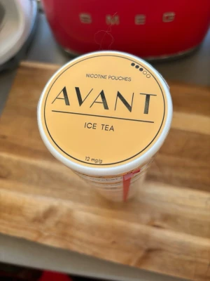 Avant Ice Tea nikotinpåsar - Säljer en burk Avant nikotinpåsar med smak av Ice Tea. Burken är gul och vit med tydlig märkning och innehåller 12 mg/g nikotin. Tillverkad i Sverige och har en modern, stilren design. Förvaras välkyld. Bäst före 2027