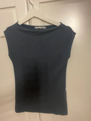 Mörkblå  topp från 157 - En enkel och stilren mörkblå topp från 157. Modellen har en tight passform. Perfekt att matcha med jeans eller kjol för en clean look.