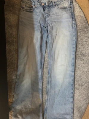 Ljusblå raka jeans - Säljer ett par ljusblå jeans med rak passform . Jeansen har en något tvättad look och låg midja. Perfekta för en avslappnad och trendig stil. Stängs med knapp och dragkedja. Storlek XXS-XD