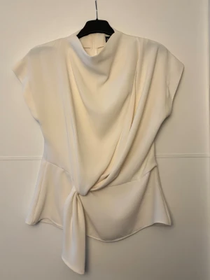 Krämvit blus från Zara - Säljer denna superfina blusen från Zara, endast använd fåtal gånger. I storlek XS men passar även S