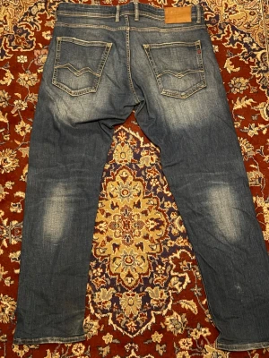  jeans från Replay - Säljer ett par klassiska blå jeans från Replay med raka ben och snygga slitningar framtill och baktill. Skriv för frågor. Straight fit/slim fit, KAN DISKUTERA PRIS