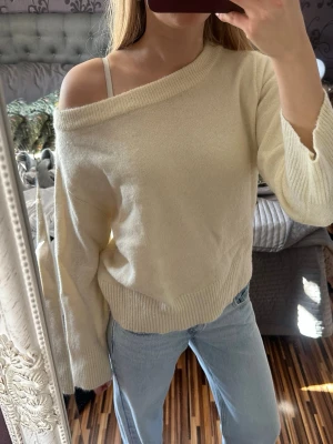 Off shoulder stickad tröja från Gina tricot - Trendig gul stickad tröja med off shoulder-design och bred ribbad kant nedtill. Tröjan har långa ärmar och en avslappnad passform. Köpt från Gina Young. Använd ett fåtal gånger 