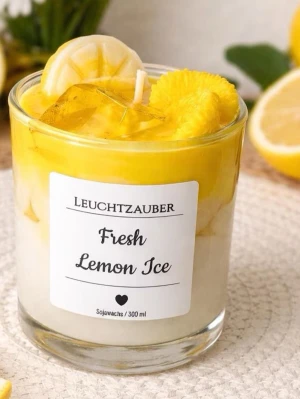 Doftljus Fresh Lemon Ice Leuchtzauber - Säljer ett doftljus i glas från Leuchtzauber med doften Fresh Lemon Ice. Ljusets design har gula och vita nyanser och dekorationer som ser ut som citronskivor. Tillverkat av sojavax och rymmer 300 ml. Perfekt för att skapa en fräsch känsla hemma.