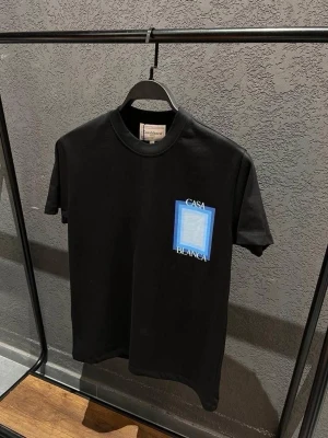 Svart Casa Blanca t-shirt med tryck - Snygg svart t-shirt från Casa Blanca med ett grafiskt tryck i blått och vitt på både bröstet och ryggen. T-shirten har rund hals och korta ärmar. Perfekt för dig som gillar stilrena plagg med en twist.