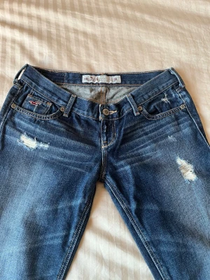 Hollister jeans - Fick precis ett par superfina vintage jeans från Hollister från 2005 med väldigt låg midja. Tyvärr måste jag sälja vidare dem eftersom de var för små 😢❤️  Midja: 33 cm Innerbenslängd: 80 cm Material: 100 % bomull  Scrolla till sista bilderna för att se hur byxorna sitter på. (Observera att jag inte fick på mig jeansen helt, så de kan se längre ut än vad de faktiskt är.) jag är 162 cm!