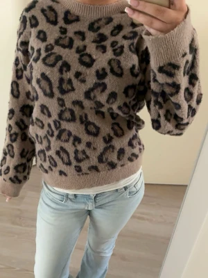 Brun leopardmönstrad tröja - Säljer en brun stickad tröja med leopardmönster i svart och är i storlek 158/164 skit snygg men kommer inte till användning super len men lite trådar 