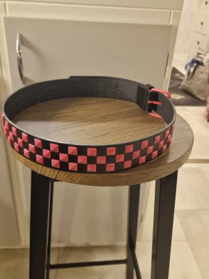 Skärp punk pyramidnitar röd - Skärp punk. Röd Rhinestone. PU läder. 112 cm längd. Bredd 3,8 cm.