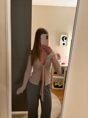 Ljusrosa topp med knyt - Trendig ljusrosa topp med långa ärmar och knyt framtill. Tunn och mjuk i materialet. Funkar med linne under också.  Fin till sommaren. Använt fåtal gånger. Priset kan diskuteras❣️