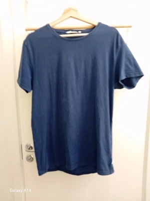 Mörkblå basic t-shirt - En enkel och stilren mörkblå t-shirt med rund hals och korta ärmar. Perfekt till jeans eller shorts för en avslappnad look. Tillverkad i mjuk bomull som känns skön mot huden.