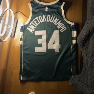  Milwaukee Bucks #34 - Milwaukee Bucks basketlinne från Nike med  34an Antetokounmpo på ryggen. Linnet har vita och beige detaljer och är i mycket bra skick. Perfekt för basketfans, så jävla snygg!!