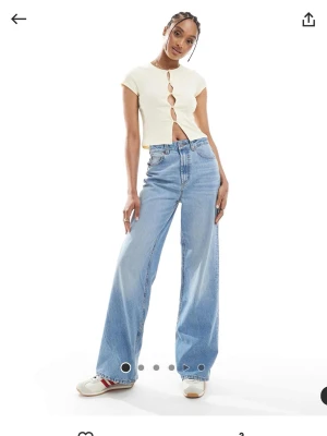 Vida ljusblå jeans med hög midja - ASOS tall - Säljer ett par trendiga ljusblå jeans med hög midja och vida ben. Jeansen har klassisk femficksdesign och stängs med dragkedja och knapp. Perfekta för en avslappnad och cool stil. Materialet är denim i bomull.