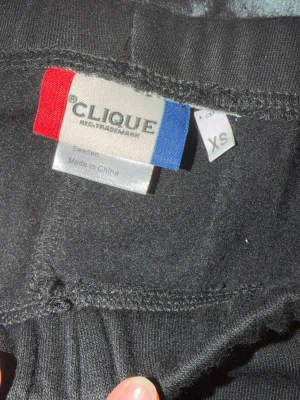 Svarta mjukisbyxor från Clique XS - Svarta mjukisbyxor från Clique i storlek XS. Byxorna har dragsko i midjan, muddar vid bensluten och sidofickor. Tillverkade i mjukt och bekvämt material som passar perfekt för chill dagar. Klassisk rak passform och enkel stil.