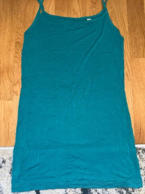 Turkos linnetopp  - Säljer en enkel och snygg turkos linnetopp från Esprit Essentials. Toppen har smala axelband och ärmlös design, perfekt för varma dagar. Tillverkad i mjuk bomull som känns skön mot huden. Passar till jeans, shorts eller kjol.