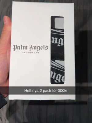 Palm Angels 2-pack svarta kalsonger - Säljer ett 2-pack svarta kalsonger från Palm Angels. Kalsongerna har bred resår med vit logga och grafiskt mönster. Snygg och modern design, perfekt för dig som gillar streetwear och exklusiva märken.