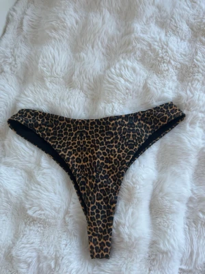 Leopardmönstrad bikiniunderdel - Snygg bikiniunderdel med leopardmönster i bruna och svarta toner. Modellen har hög skärning och smal passform.