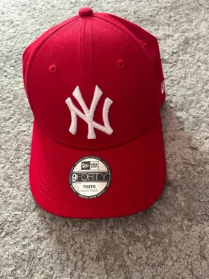 Röd New Era NY Yankees keps - Snygg röd keps från New Era med klassisk New York Yankees-logga broderad i vitt framtill. Helt oanvänd. Skriv om du har några frågor💕