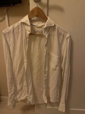 Vit skjorta från Eton - vit skjorta från Eton i luftigt linne. Skjortan har lång ärm, bröstficka och knappar framtill. Perfekt för en clean och stilren look.