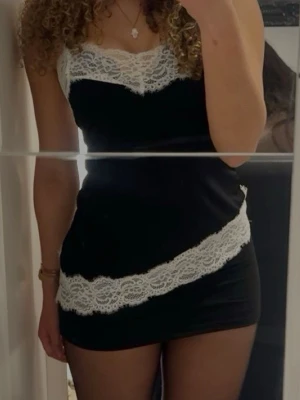 Topp - Snygg svart kort topp. Figurnära passform och ärmlös design, perfekt för dig som vill sticka ut. Topp  har en feminin och trendig look med fina spetsdetaljer.