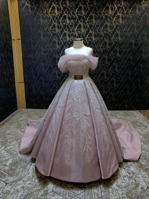 Ljusrosa balklänning med glitterdetaljer - Magisk ljusrosa balklänning med offshoulder-design och glittriga broderier över hela livet och kjolen. Klänningen har en lång, vid kjol med släp och markerad midja. Perfekt för bal eller festliga tillfällen. Materialet har en skimrande finish.