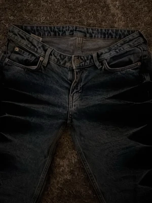 Blåa bootcut jeans med mönster - PRIS KAN DISKUTERAS! Säljer ett par blåa bootcut jeans med unikt blekt mönster längs benen. Jeansen har klassisk femficksdesign, knapp och dragkedja framtill. Perfekta för dig som vill sticka ut med en cool och trendig look. Inte mina bilder.