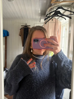 Mörkblå oversized stickad tröja - Mysig oversized stickad tröja i mörkblått med lång ärm och rund hals. Tröjan har en fluffig struktur och är perfekt för lager på lager. Passar dig som gillar en avslappnad och trendig look.