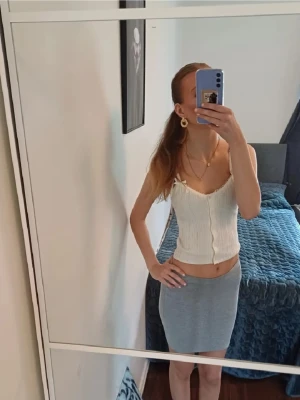 Ljusgrå tight kjol  - Säljer en enkel och stilren ljusgrå kjol i mjukt matrial. Kjolen är tight och har en rak, kort modell som sitter snyggt på kroppen. 