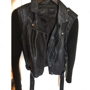  - Snygg skinnjacka med armar i koftmaterial.