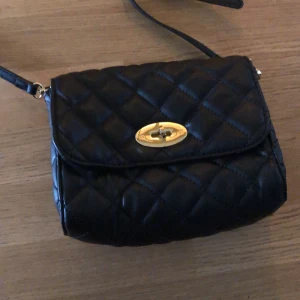 Svart axelväska - En axelväska som bara är använd ett fåtal gånger, i fint skick.  Köparen står för frakten. Buda i kommentarerna. 