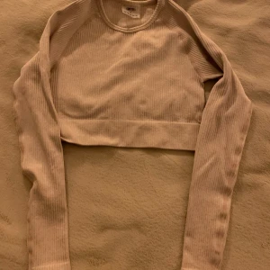 Träningstopp - Säljer en beige crop top från Aimn. Den är i strl S . Aldrig använd så är i nyskick.