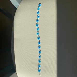 Halsband, prälor, blommor - Halsband i ljusblått, mörkblått och vitt. Sitter som en choker och med lås                                                          Frakt tillkommer på 11kr dvs frimärket.                              Jag gör smyckerna själv och därför går det att önska färg/mönster och om det ska vara en ring, ett halsband eller armband! Bara att skriva i kommentarerna