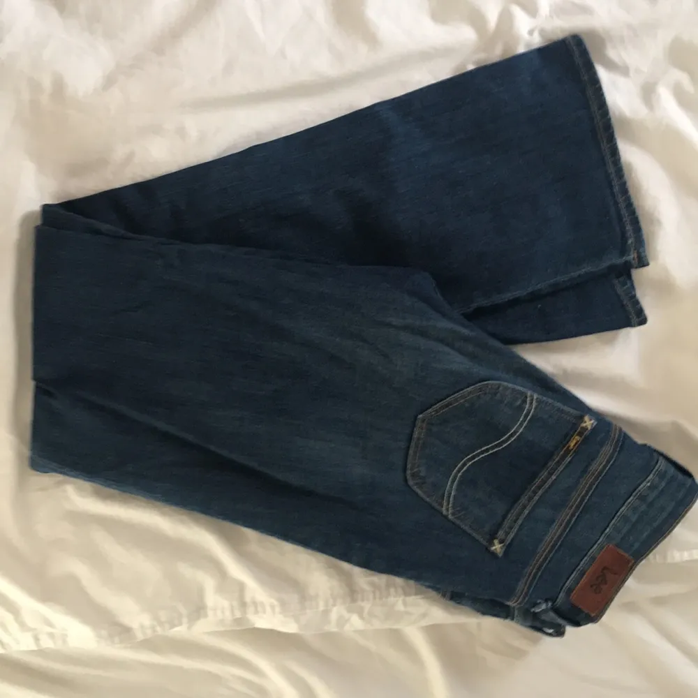 Oanvända bootcut jeans från lee, storlek W27L31. . Jeans & Byxor.