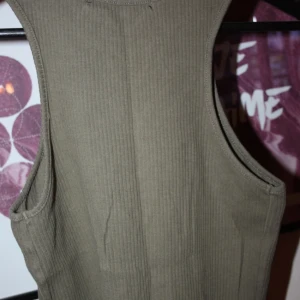  - Militärgrönt linne från BikBok. Aldrig använt :) Storlek small/36.   Frakt kostar 25kr. Kan även mötas i Vallentuna, Täby C, TC eller i Vällingby C :)