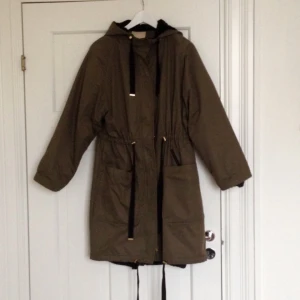  - Grym parkas från H&M, militärgrön med svarta och guldiga detaljer. Utmärkt som både höst-vinter- och vårjacka! Uttagbart foder.  