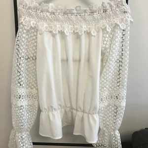 Underbar topp med broderi - Så fin off the shoulder topp med ärmar av broderi. Med en hudfärgad bh under blir det supersnyggt! Använd 1 gång! Står L i den men mer som en Medium.
