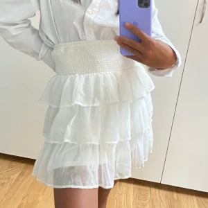 Kjol vero Moda M - Vit volangkjol från Vero Moda i storlek L, dock stretch så passar M lika bra! Skulle sy in midjan när jag köpte den men blev aldrig av, därmed aldrig använd så i fint skick! Fraktar mot en avgift på 63kr spårbar frakt (1-2 dagars leveranstid). 