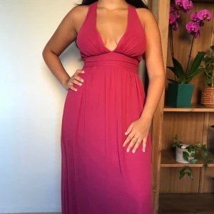 Mörkrosa klänning - Fin mörkrosa klänning med öppen rygg. Den är endast använd en gång och därmed i prima skick. Modellen är 163cm. 