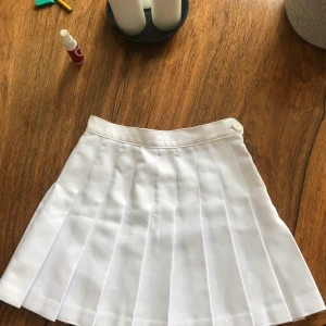 Tenniskjol/minikjol - Skitsnygg tenniskjol från American apparel jag fyndade här på plick! Säljer pga att den är för liten för mig. Jag är 171 cm och har oftast S. Om du har XS bör den passa och om du har frågor om mått m.m tveka inte på att höra av dig!✨💓🤩