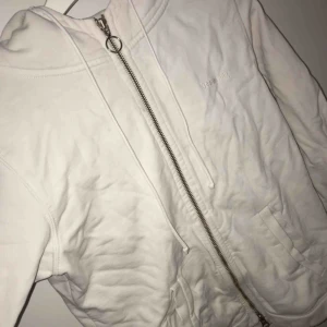  - En vanlig vit kofta. Som man kan ha på sig om de är lite kallt eller blåsigt ute. Den är lite skrynklig hör på bilden. Men de går att ordna.