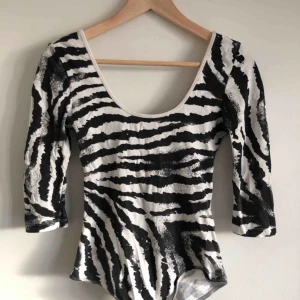  - Zebra randig body med 3/4 ärm.  Supersnygg passform med urringning fram och bak.  Knäppning nertill.  Pris utan frakt. 