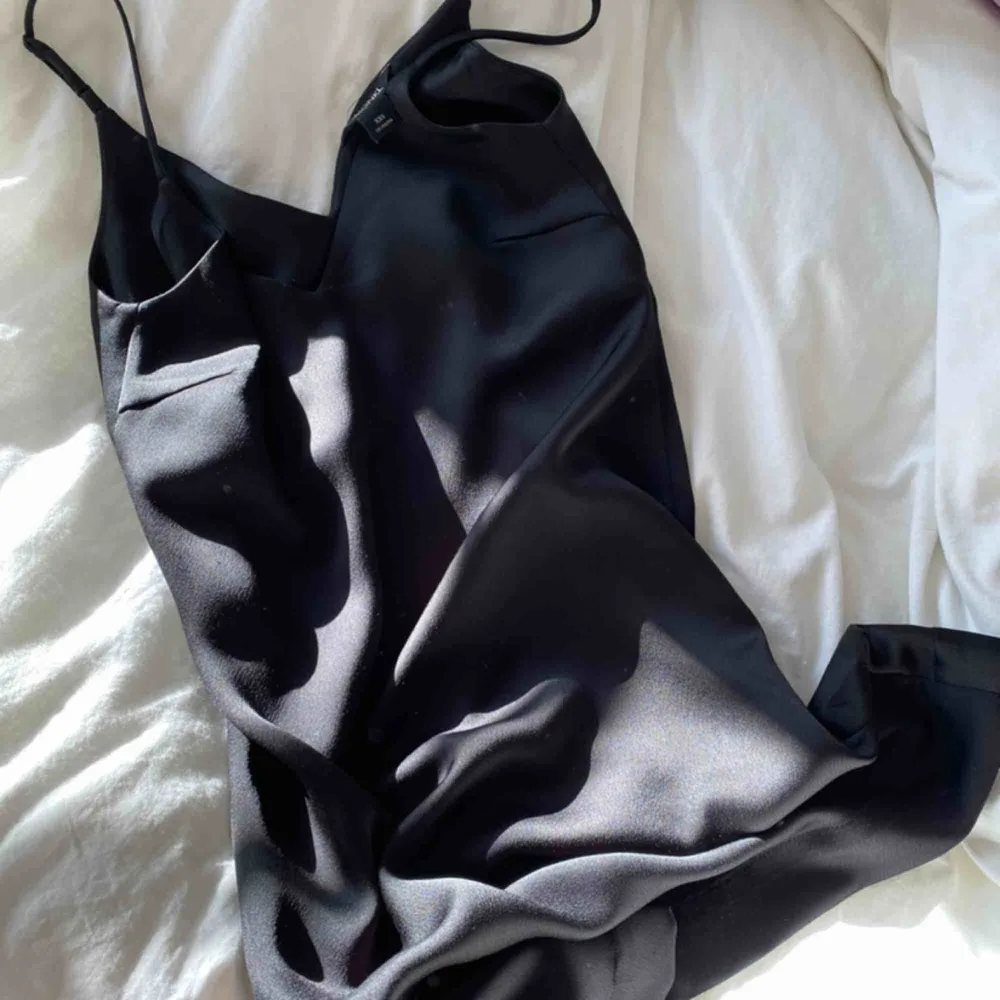 Kort och svart klänning i ”sidenmaterial”. Klänningar.