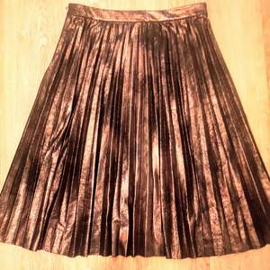 Bronsfärgad plisserad kjol. 66cm lång. Köparen står för frakten.