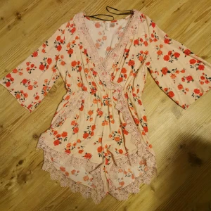  - SÖT BLOMMIG PLAYSUIT med spets detaljer  ALDRIG ANVÄND STRL 42 HM