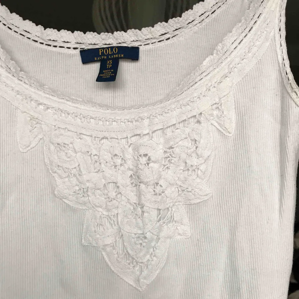 Ribbad Polo Ralph Lauren linne i bomull med virkade detaljer i storlek XS. Perfekt till sommaren eller under en kofta på hösten. . Toppar.
