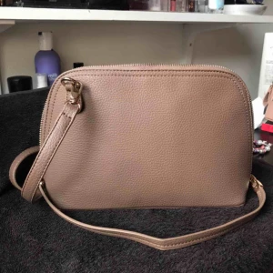  - Superfin liten väska med en lång axelrem, avtagbar och reglerbar. Flera fack inuti. Aldrig använd😊