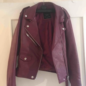  - Fejk vinröd skinnjacka från Bershka. Storlek L men tycker den är rätt liten så passar definitivt en M! Fint skick! Köpare står för frakt, annars kan vi mötas i Malmö. 